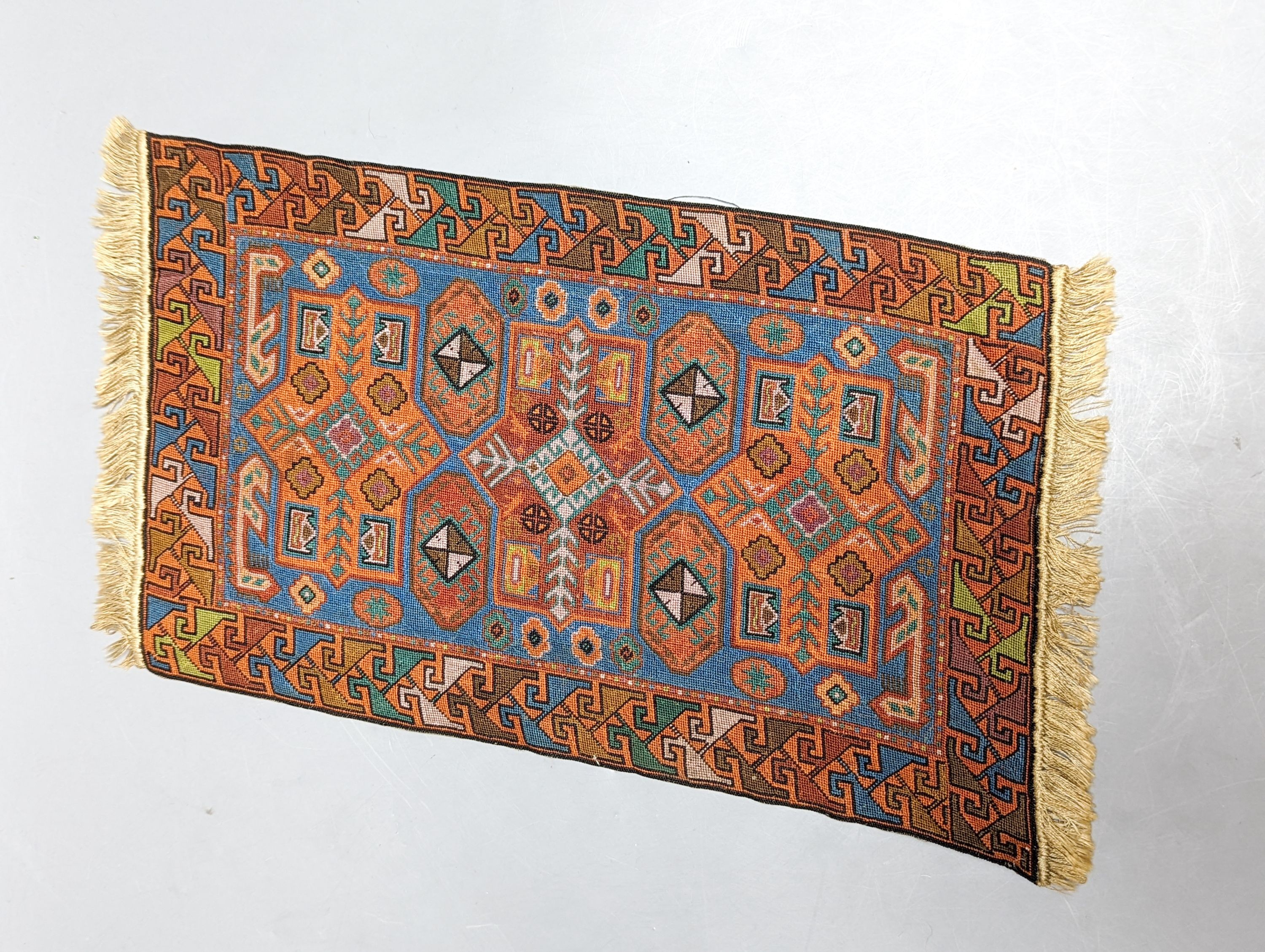 A Caucasian style petit point miniature rug 33x20cm